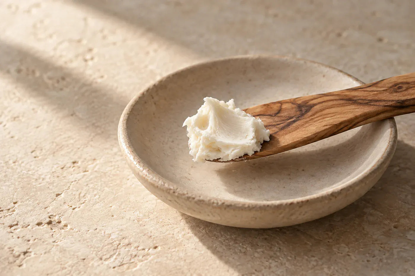 A small scoop of pale Whipped Tallow on a wood spatula